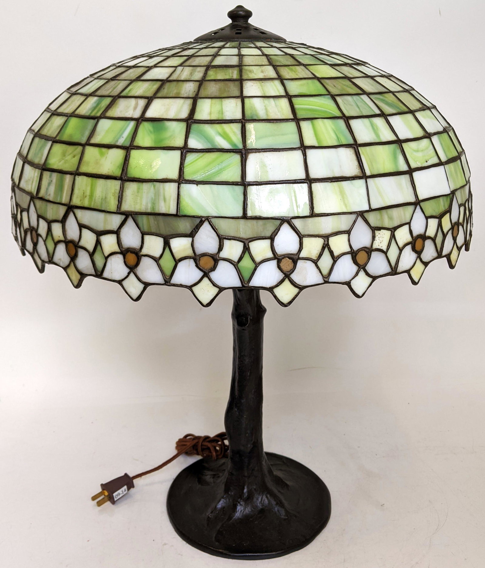 Leaded Glass & Bronze Table Lamp: Table lamp with leaded glass shade, on bronze base. Base stamped "Handel". [22 1/2" H x 18" Diam. (shade)]. Hairline cracks.