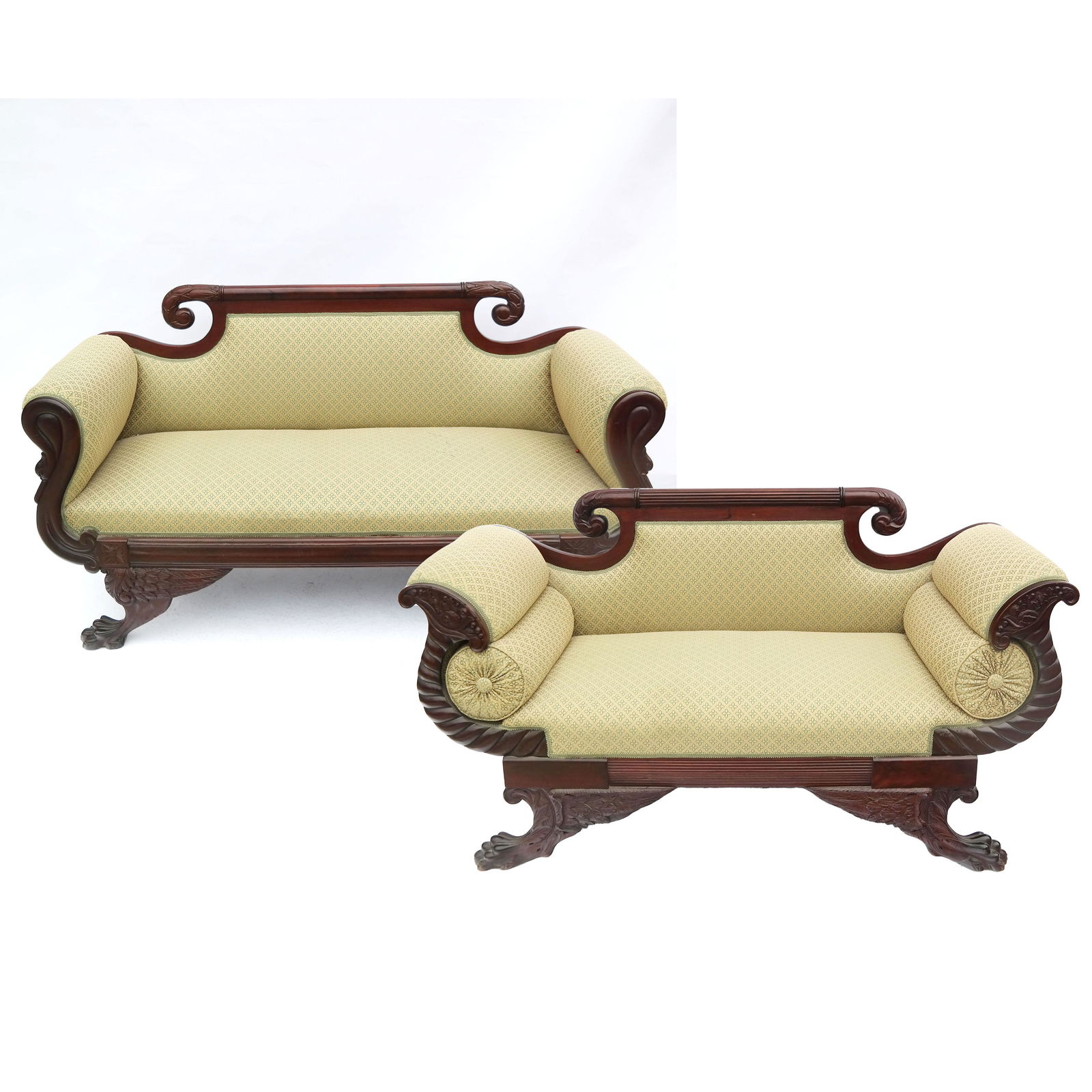 Pair of American Empire-Style Mahogany Settees: Pair of American Empire-style mahogany settees with scroll end crests and wing carved bases, in green upholstery. [36" H x 66" W x 25" D]. In good condition.