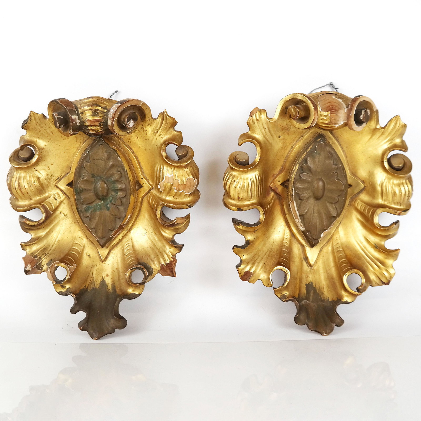 Pair of Gilt Carved Wood Appliques: Pair of gilt carved wood appliques, of scrolling shell form, 20th century, but with some age. [10 1/2" H x 8 1/2" W x 4" D]. Chipping of gilt and paint; one with repaired crest.