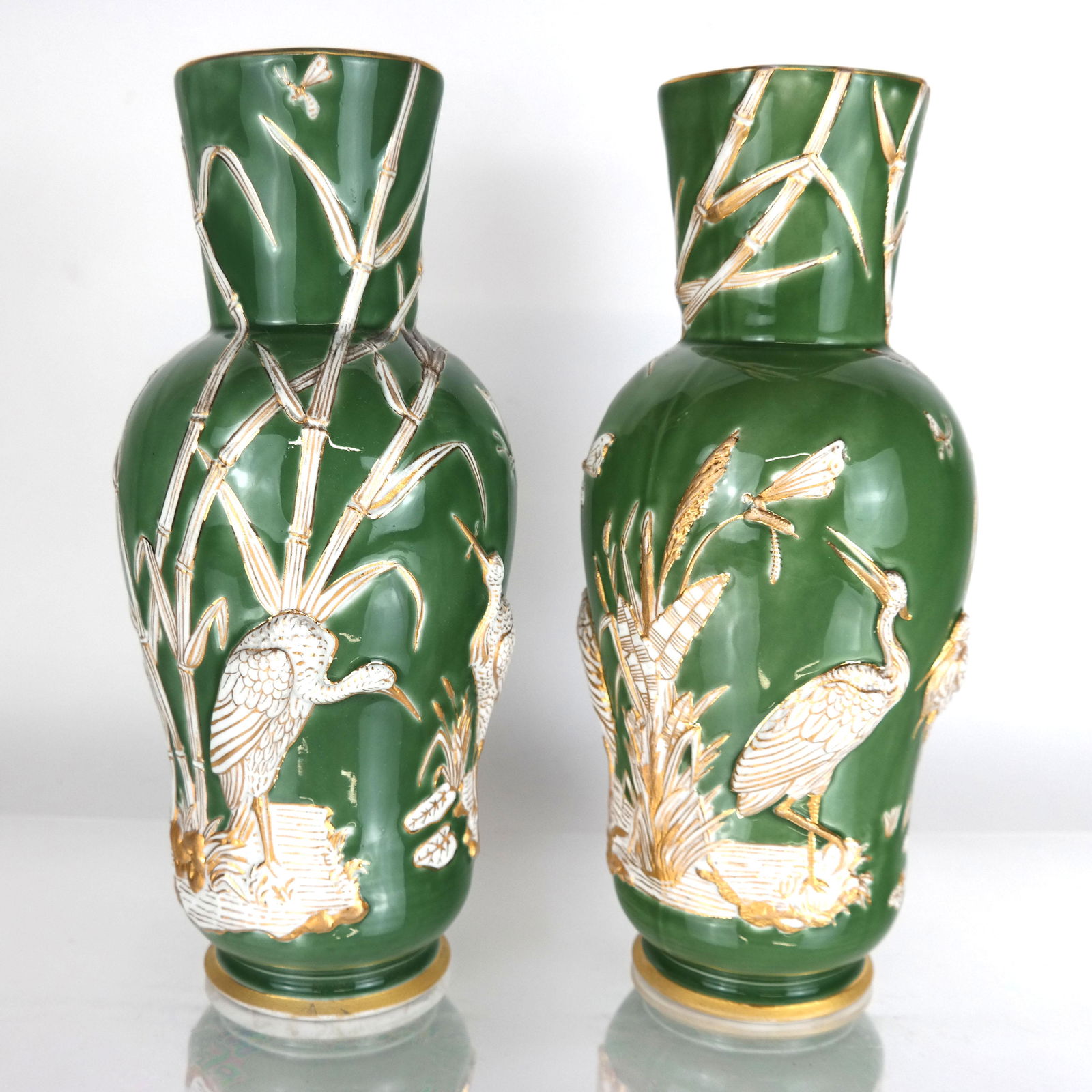 Pair of Crane Motif Green Vases: Pair of French St. Amiens porcelain vases, celadon color ground with raised (molded) white and gilt crane and reed design. 20th century. Surface in an oval white raised mark on underside. [11 5/8" H x