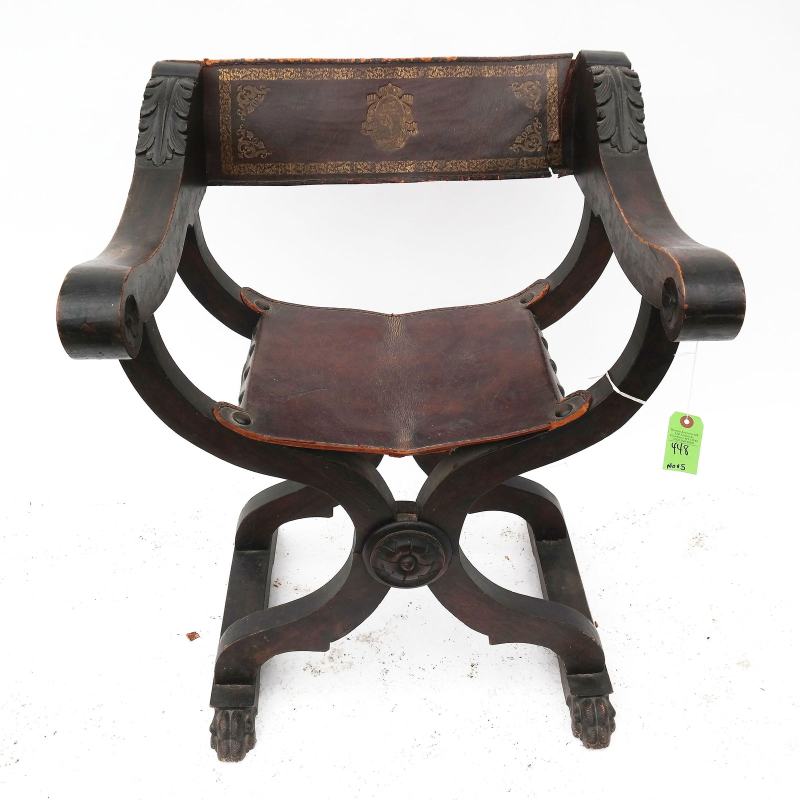 Antique Savanarola Arm Chair: Savanarola arm chair with carved leaf corners, paw feet, thick leather back and seat. [34" H x 27" W x 23" D]. Back tearing.