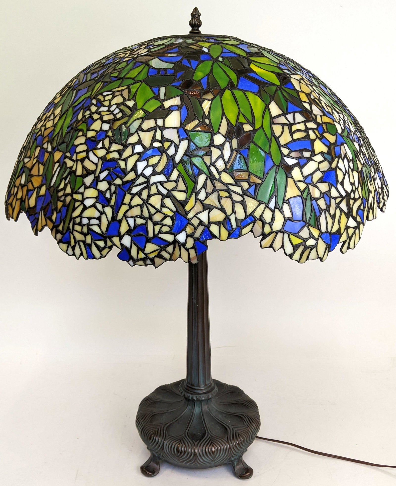 Leaded Glass Table Lamp: Table lamp with floral leaded glass shade, on patinated metal base. [28 1/2" H x 23" Diam. (shade)]. Hairline cracks; slightly bent.
