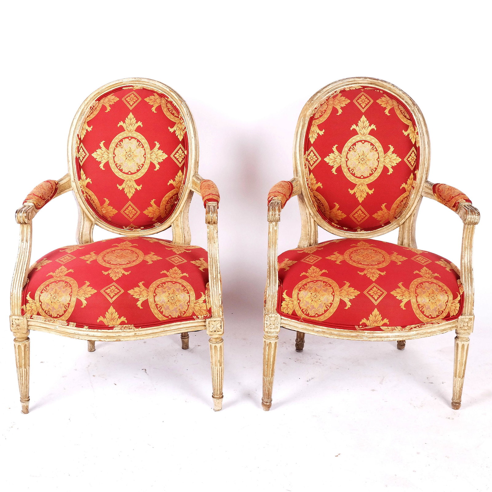 Pair of Louis XVI-Style Fauteuils: Pair of Louis XVI-style fauteuils, 20th century, the upholstered open armchairs on tapered fluted legs. [35 1/4" H x 24" W x 21" D]. Overall with stains, wear and losses.