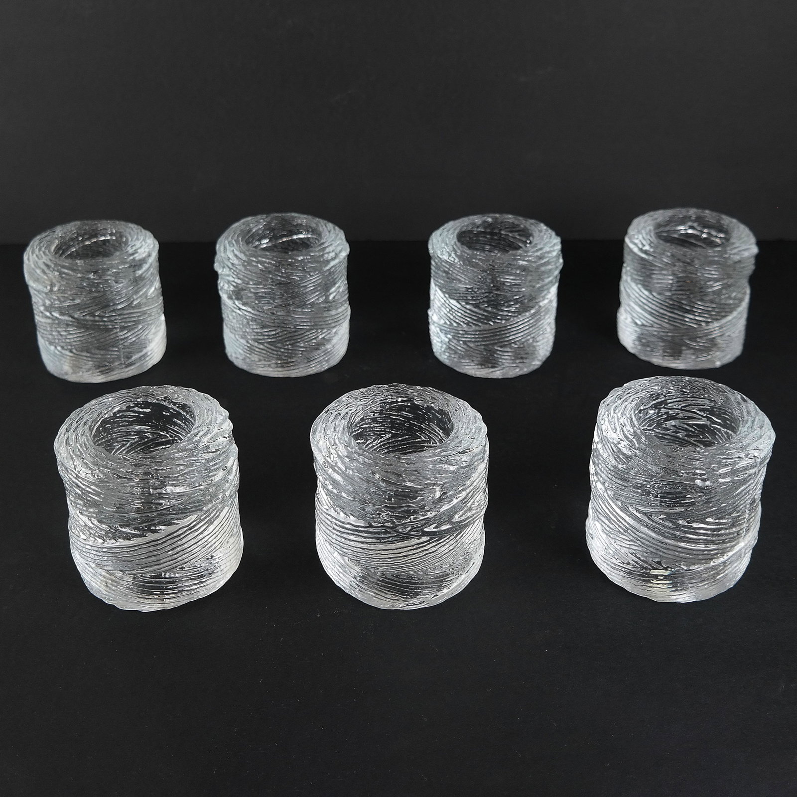 Set of Seven Glass Votives: Set of seven glass votives, in the form of twines of string. Made for Tiffany. [3" H x 3" W].