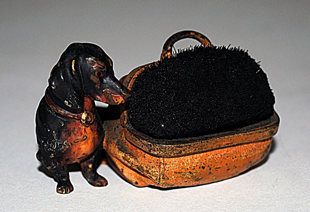 Figural Vienna Bronze Daschund Pen Wipe: Figural Vienna Bronze Daschund Pen Wipe. Depicts a realistic cold painted daschund standing beside a luggage form pen wipe. 2-1/2"W x 2"D x 1-1/2"H.