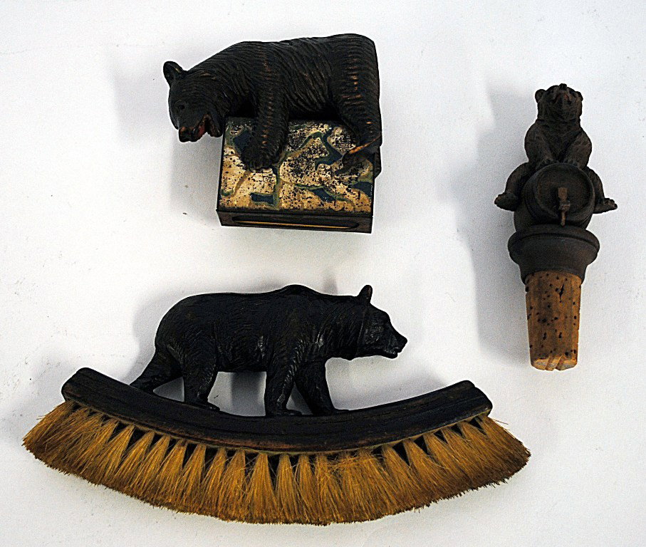 Group Of Carved Wood Bear Items: Group of carved wood items comprising: a black forest bear form clothing brush, a black forest bear form cork stopper, and a bear form match safe. Varying Dimensions from 1-7/8" to 6-1/4"W x 7/8" to 3