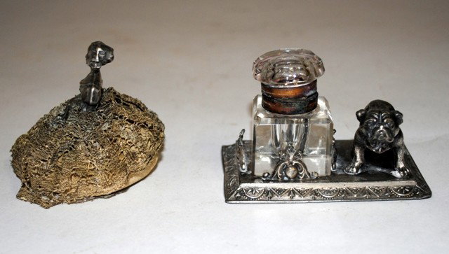 Sterling Silver Pin Cushion & Inkwell: Sterling Silver Figural Pin Cushion. Depicts an 18th century lady with gold thread lace dress concealing pin cushion beneath. 3"W x 2-1/2"D x 2-1/8"H. Accompanied by a bull dog inkwell with cut-crysta