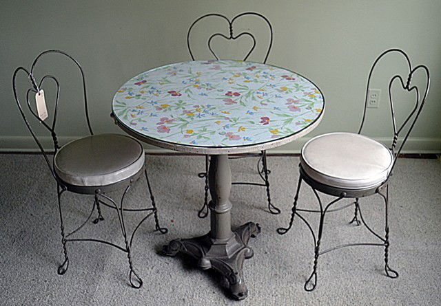 French Four Piece Bistro Set: French Bistro Set composed of three steelwire chairs with heart-form back splats. Features an Art deco circular Top, Pedestal Base, Side Table.