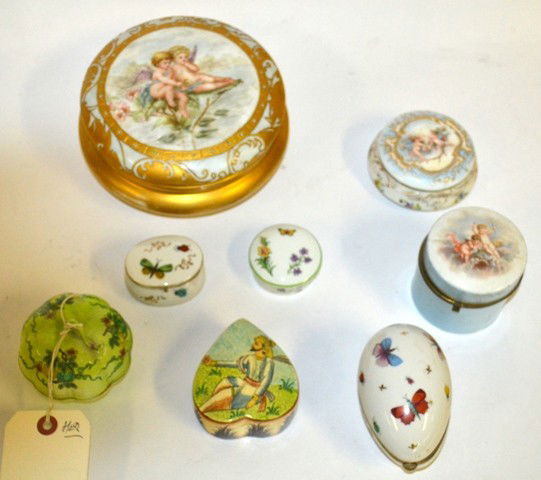 Eight Assorted Decorative Boxes: Eight Assorted Decorative Boxes Comprised of Porcelain, Glazed Ceramic, Enamel, and Papier-Mache. Themes include: Butterflies, Floral, Cherbs, and Putti. Some Chips and Cracks with Repairs.