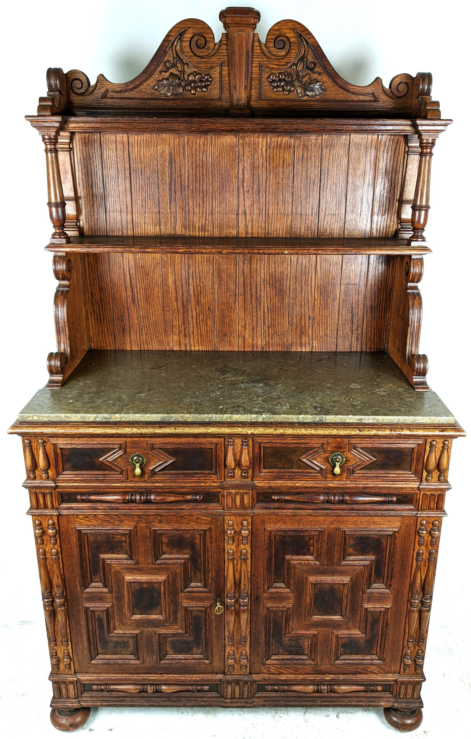 Dutch-Style Oak Two-Part Wine Cabinet: Early 20th century oak two-part carved Renaissance-style cabinet with marble top, with carved back. [73" H x 42" W x 20 1/2" D]. In good condition; missing molding. LOCATED AT 150 PRATT OVAL