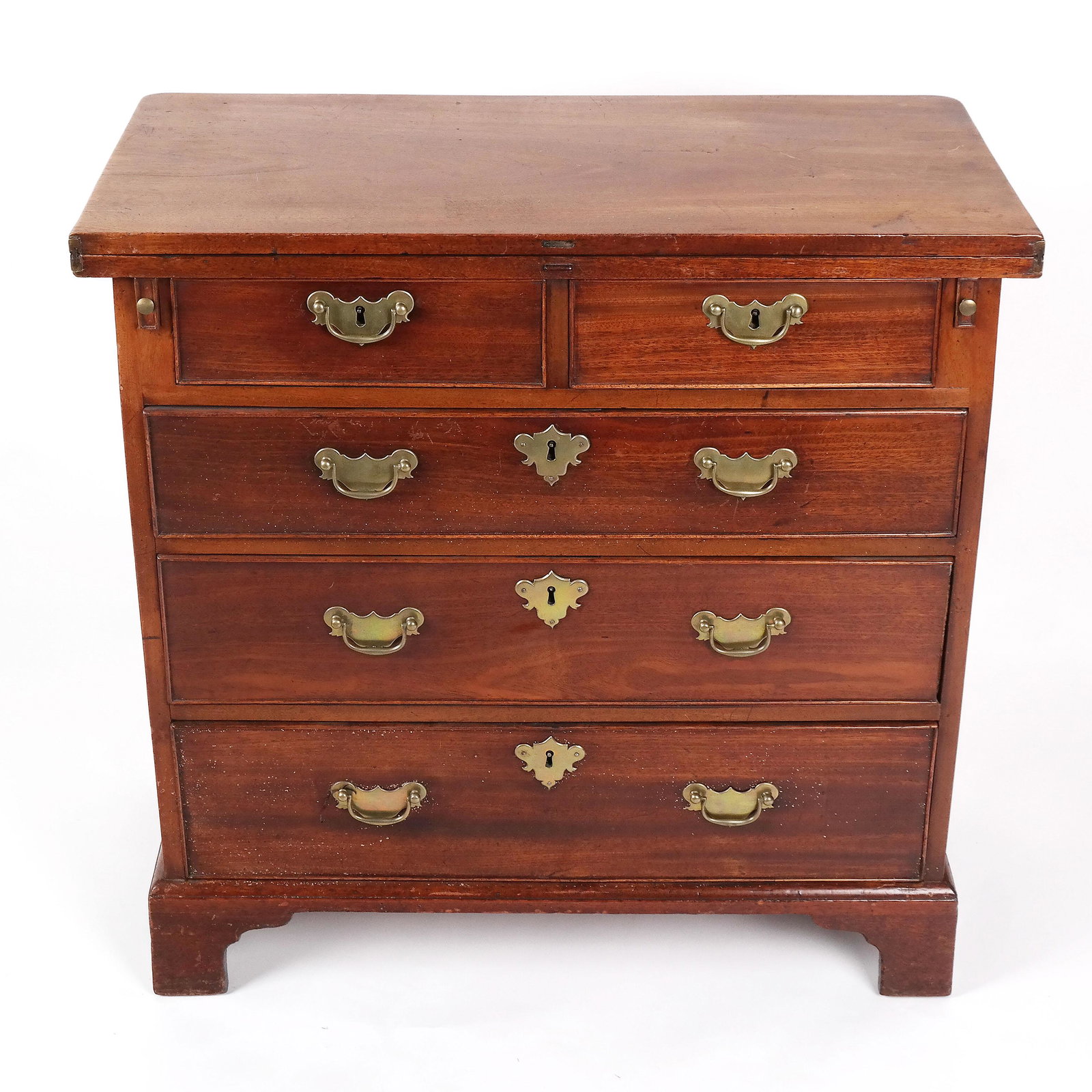 George III Mahogany Bachelor Chest: George III mahogany bachelor chest, mid-18th century, the top unfolding to rest on two support slides over two short and three long drawers, on ogee bracket feet. [31" H x 31 1/2" W x 15 1/2" D]. Bras