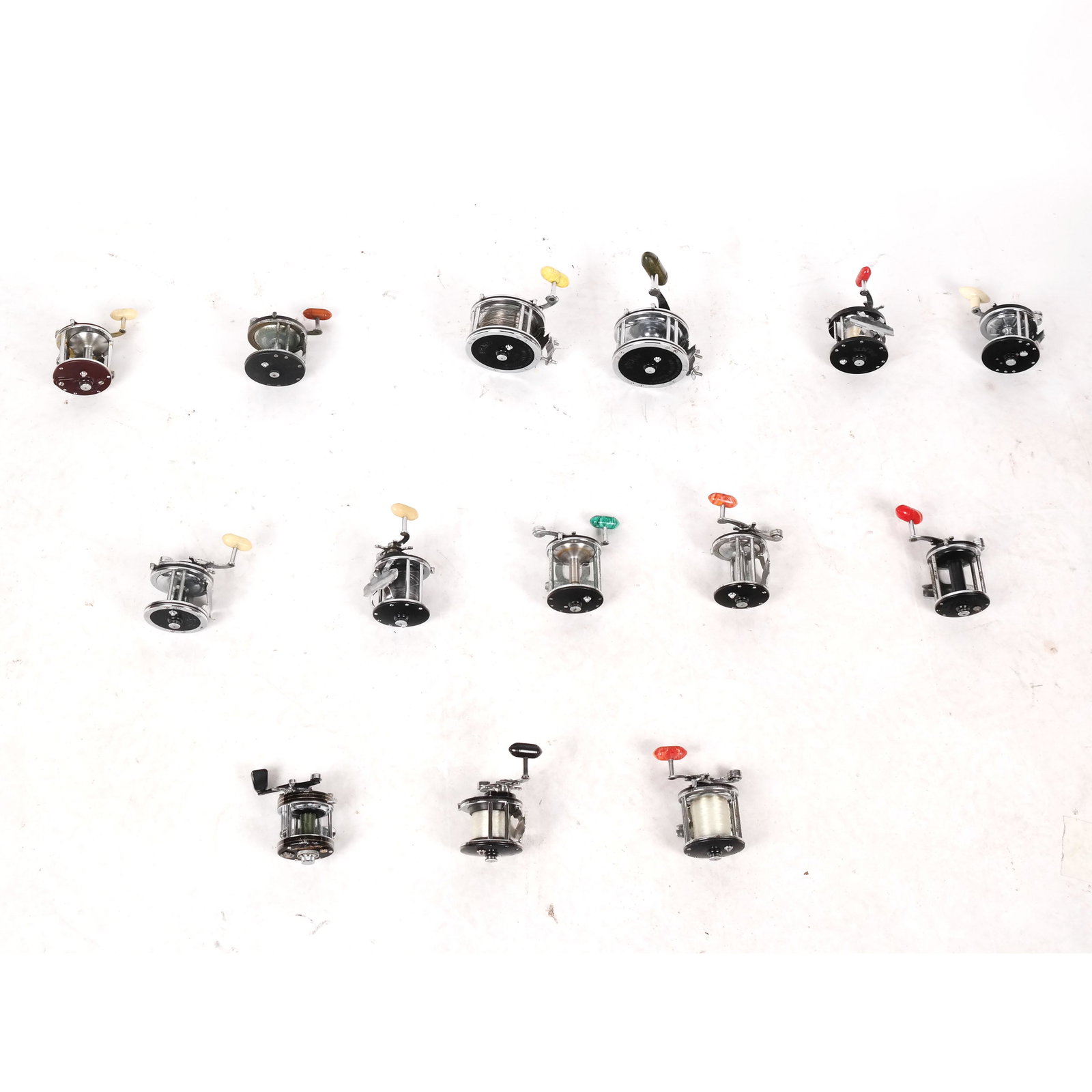 Group of Fishing Reels, Including Penn & Others: Group of fishing reels of angling interest, including 12 Penn reels with a Japanese Daiwa millionaire reel and a true temper reel. [Largest: 6 1/4" Diam.]. Some with line extant; all with residue and 
