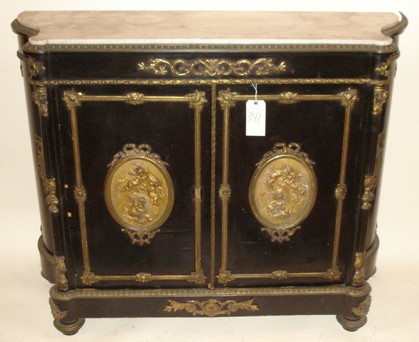 Louis Phillipe LXVI Style Two Door Cabinet: Madame Leon Bertaux black laquered, two door cabinet with two raised cupid plaques and all around bronze trim, with an inset marble top.