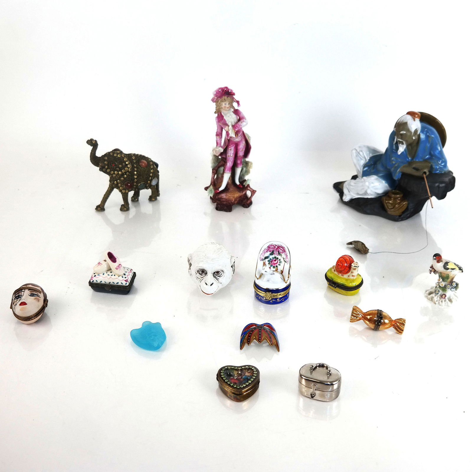 Assembled Group Porcelain & Metal Table Articles: Assembled group of porcelain and metal table articles, including figures and pill boxes, one by Rochard Limoges. [Largest: 5" H x 7 1/4" W x 8" D]. Some with losses, scuffs, and wear.