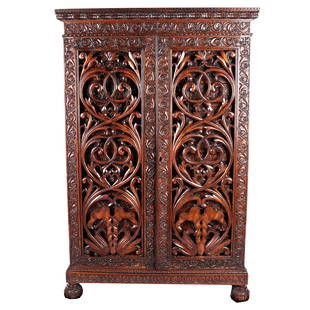 Anglo Indian Carved Wood Cabinet: 19th century Anglo Indian cabinet, possibly oak or sheesham, exuberantly carved in the manner of Lockwood de Forest with pierced foliate and scrolling motifs, numerous drawers and shelves, raised on b