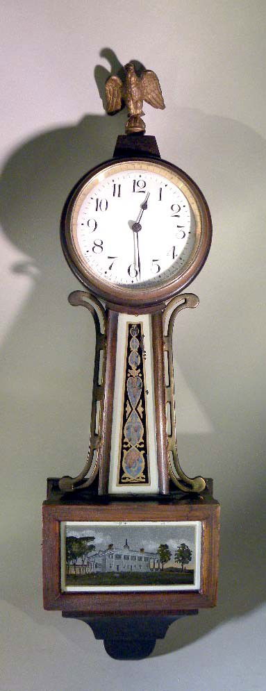 Hanging Wall Clock, New Haven Clock Co.: A hanging wall clock made by the New Haven Clock Co. with eglosmise panels and eagle finial. 18" L.