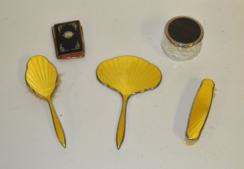 Four Vanity Table Articles: A set of yellow enamel mirror, nailbrush, and hairbrush, together with a faux tortoise shell glass vanity jar and a sterling silver inlaid coinpurse.