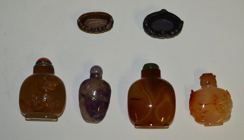 Four Glass and Hardstone Snuff Bottles: A group of hard stone snuff bottles including an amythist carved bottle together with three brown and white bottles with carved details. All with lids. Largest: 3" H. Six pieces total