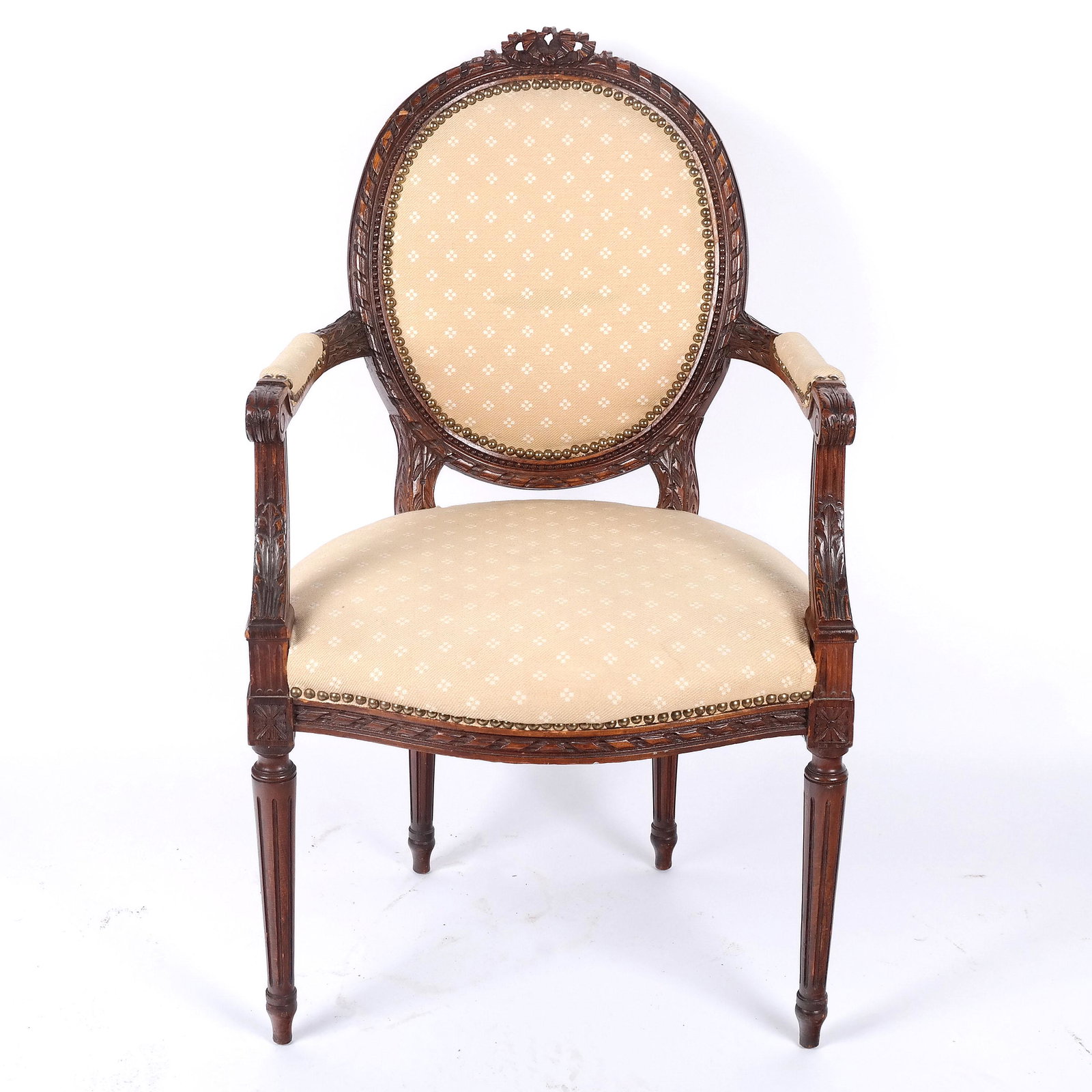 Louis XVI-Style Carved Armchair: Louis XVI-style carved armchair with ribbon and foliate details. [40" H x 24" W x 26 1/2" D]. Light wear to fabric and frame.