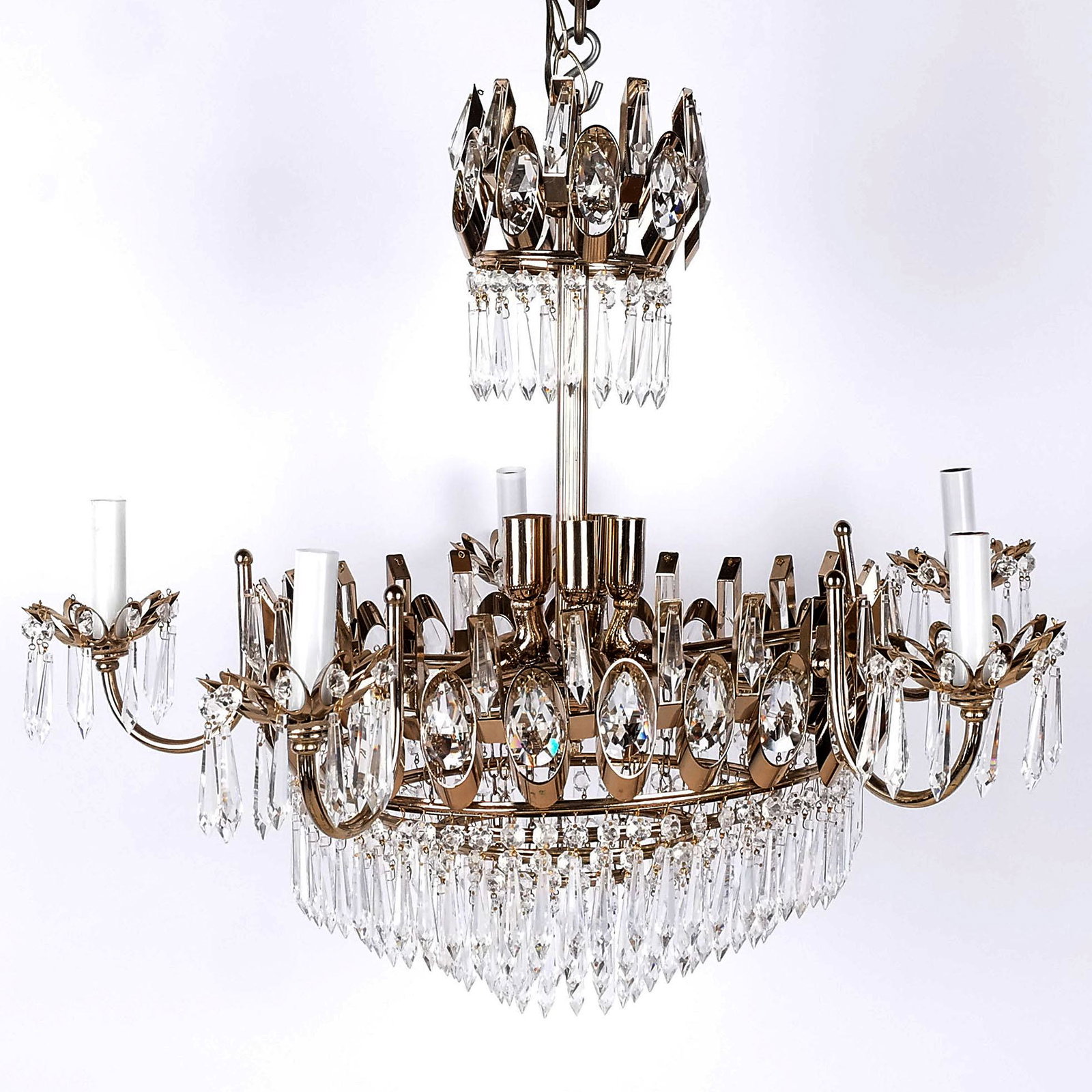 Mid-Century Retro 16-Light Chandelier: Mid-century retro 16-light chandelier in the neoclassical taste, with six arms around ten smaller lights and tiered pendant prisms. [27" H x 28" Diam.]. In overall good condition.