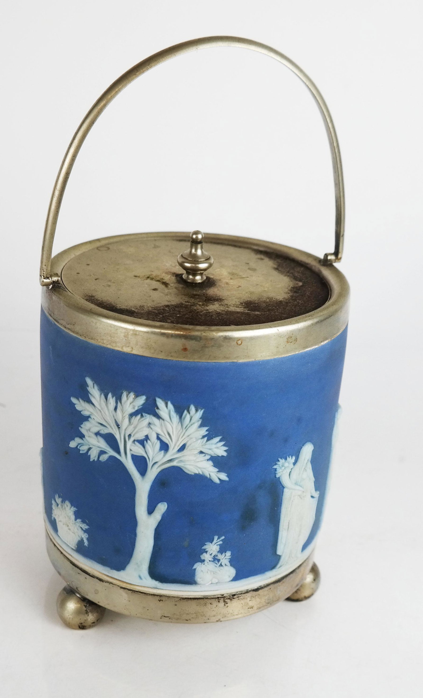 English Wedgwood Jasperware Canister: English Wedgwood Jasperware canister with silver plate mounts, marked to base. [6" H x 5 3/4" Diam.]. Oxidation to metal, marks and wear to canister.