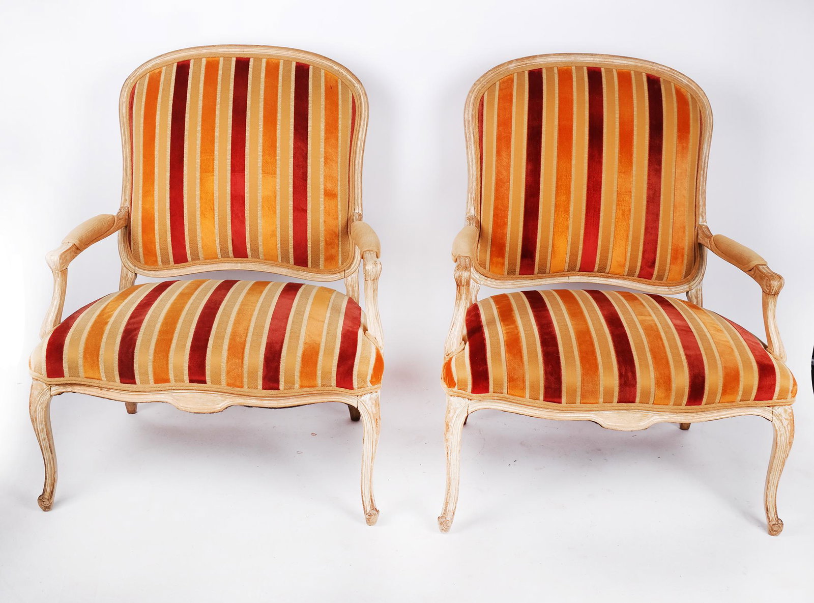 Pair of Louis XV-Style Armchairs: Pair of Louis XV-style armchairs, the fauteuils of oversized proportions, in the manner of Rose Tarlow, with striped upholstery and "pickled" finish. [44" H x 35" W x 33" D]. Some marks and wear, top 