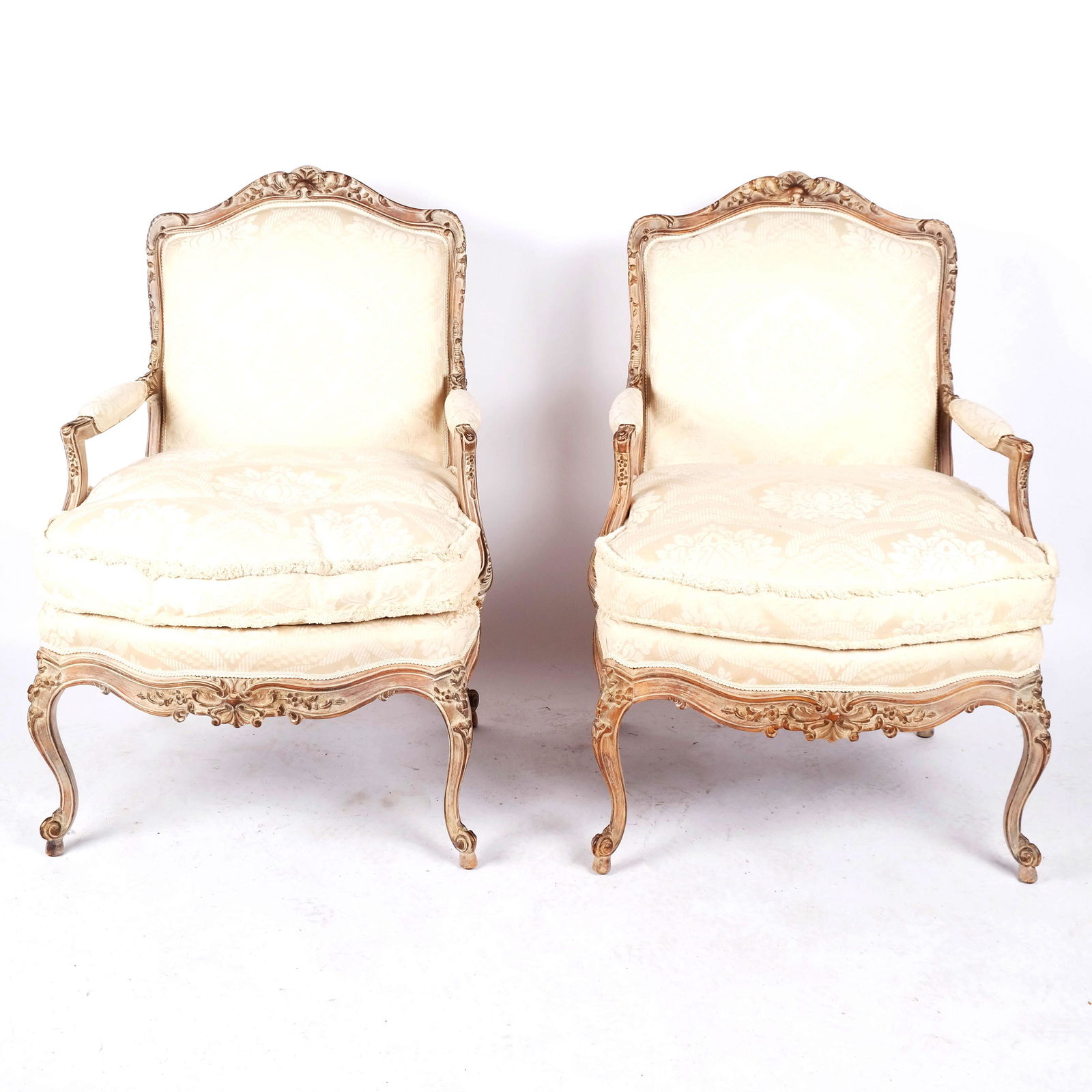 Pair of Louis XV-Style Carved & Painted Armchairs: Pair of Louis XV-style carved and painted armchairs, the fauteuil with rocaille details around upholstered back and seats, raised on cabriole legs. [40 1/2" H x 29" W x 30" D]. Stains and wear to upho