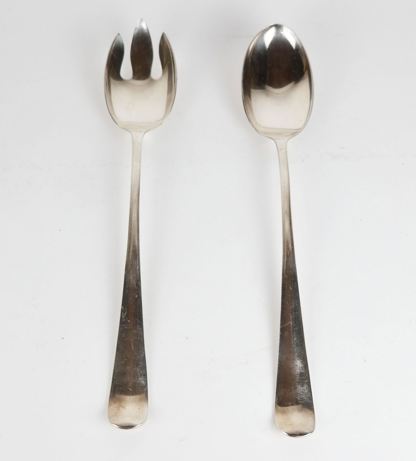 Pair of Silver Serving Pieces: Pair of silver serving pieces, including a fork and spoon in English fiddle handle-style. (10.4 ozt.) [13" L].