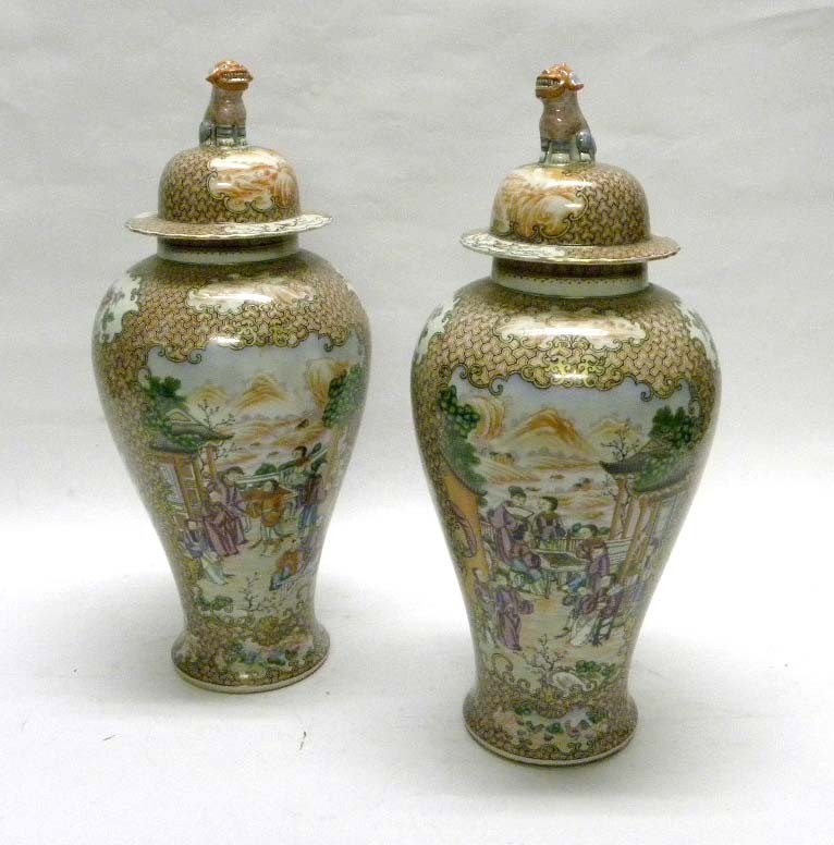 Pair of Chinese Covered Urns: A pair of Chinese covered urns in shades of orange and white with foo dog detail on lid handle. Some minor chips and losses to paint. 19" H.