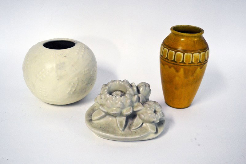 Two Pieces of Rookwood Pottery: One white with leaf design, one amber with tile design. One bookend. Tallest: 7".