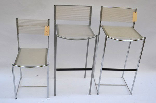 Cassina Three Stools: A pair of chrome bar stools, together with a similar, but smaller stool. Each having Rubber Webbing. Good condition.