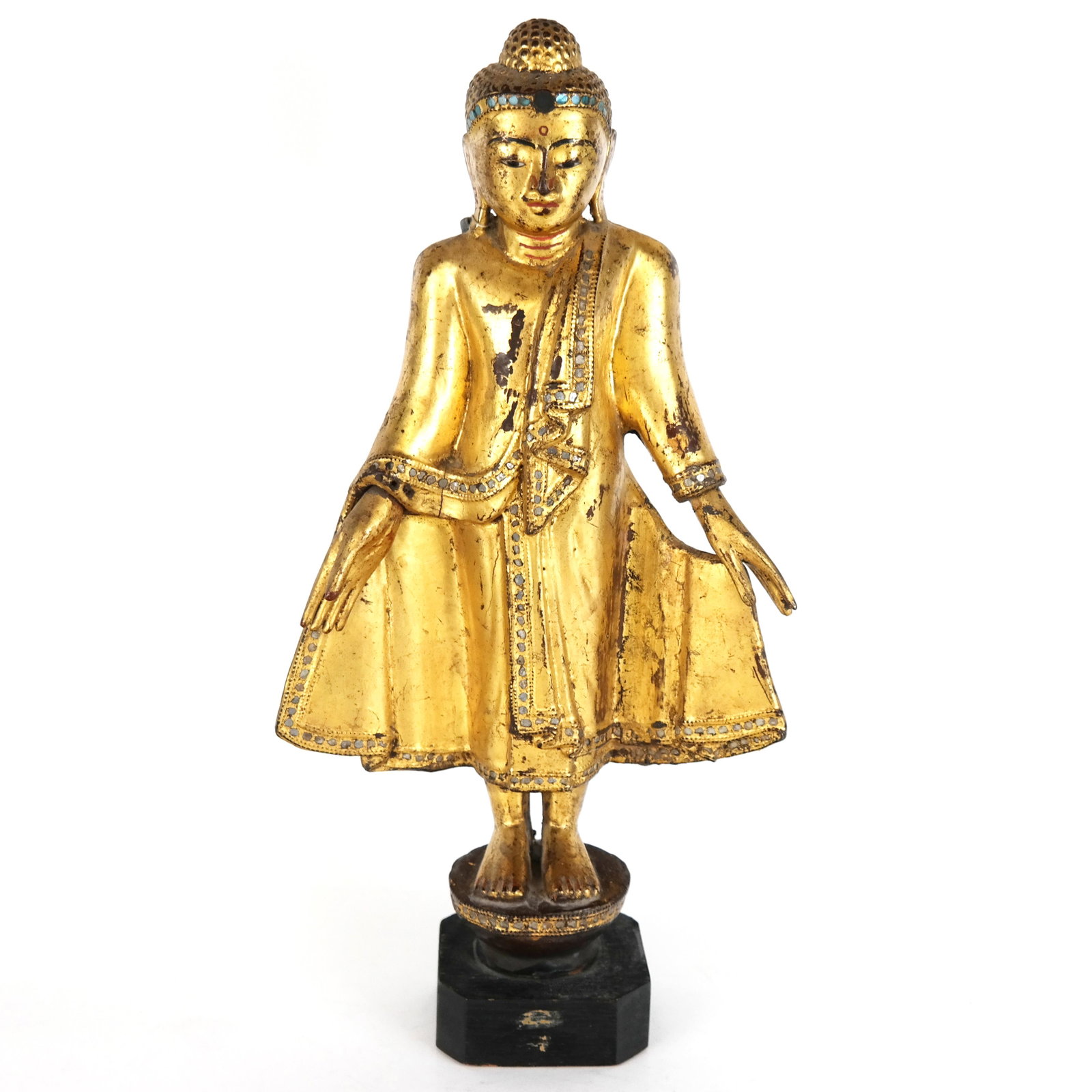 Asian Gilt Carved Buddha Figure: Asian gilt carved Buddha figure with arms and robe spread with mirror insets, on a wood stand. [17" H x 9" W x 4" D].