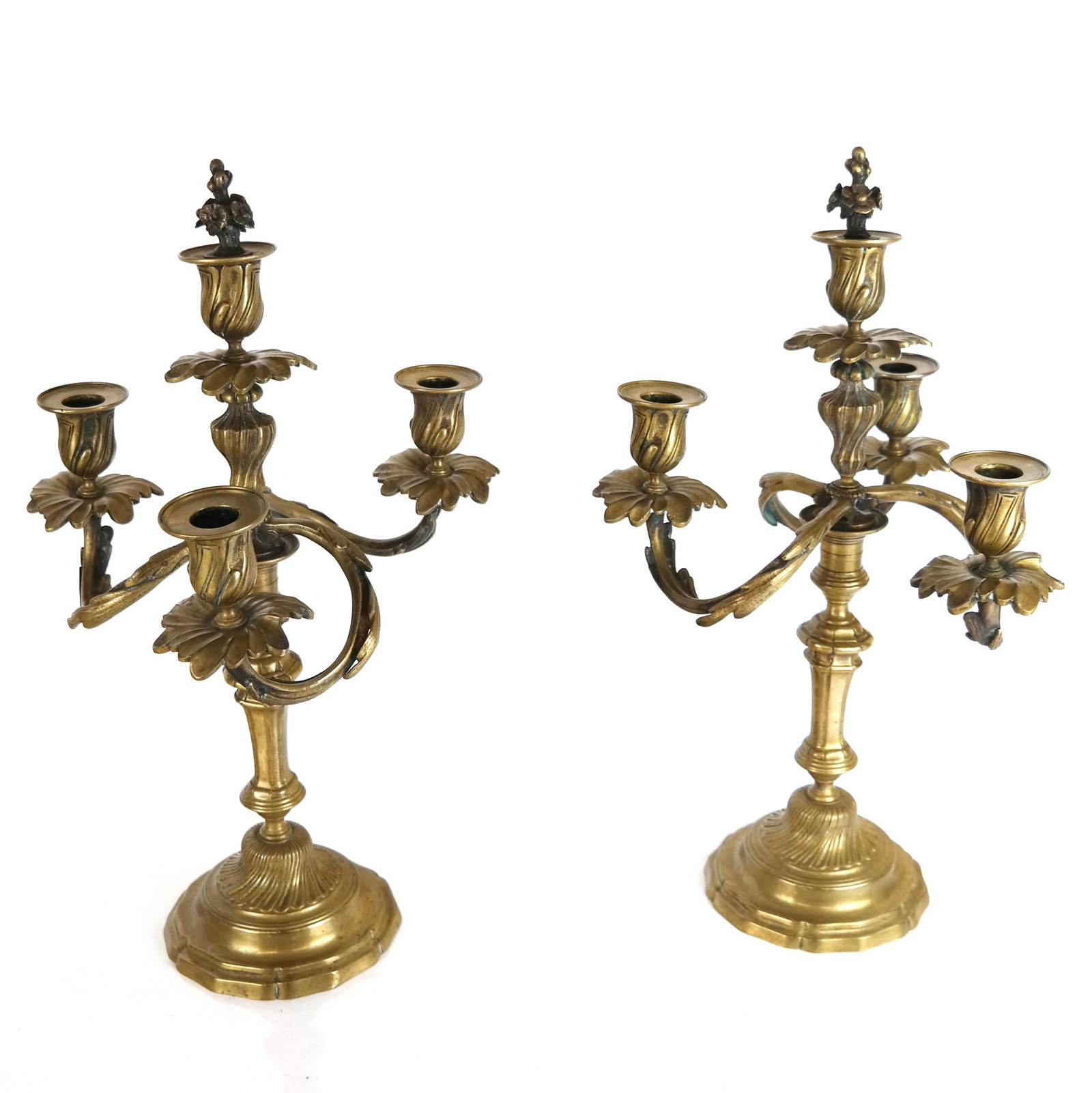 Pair of French-Style Brass Candelabra: Pair of French-style brass candelabra having a floral finial on three scrolling arms with swirl and step bases. [18" H x 11" Diam.].