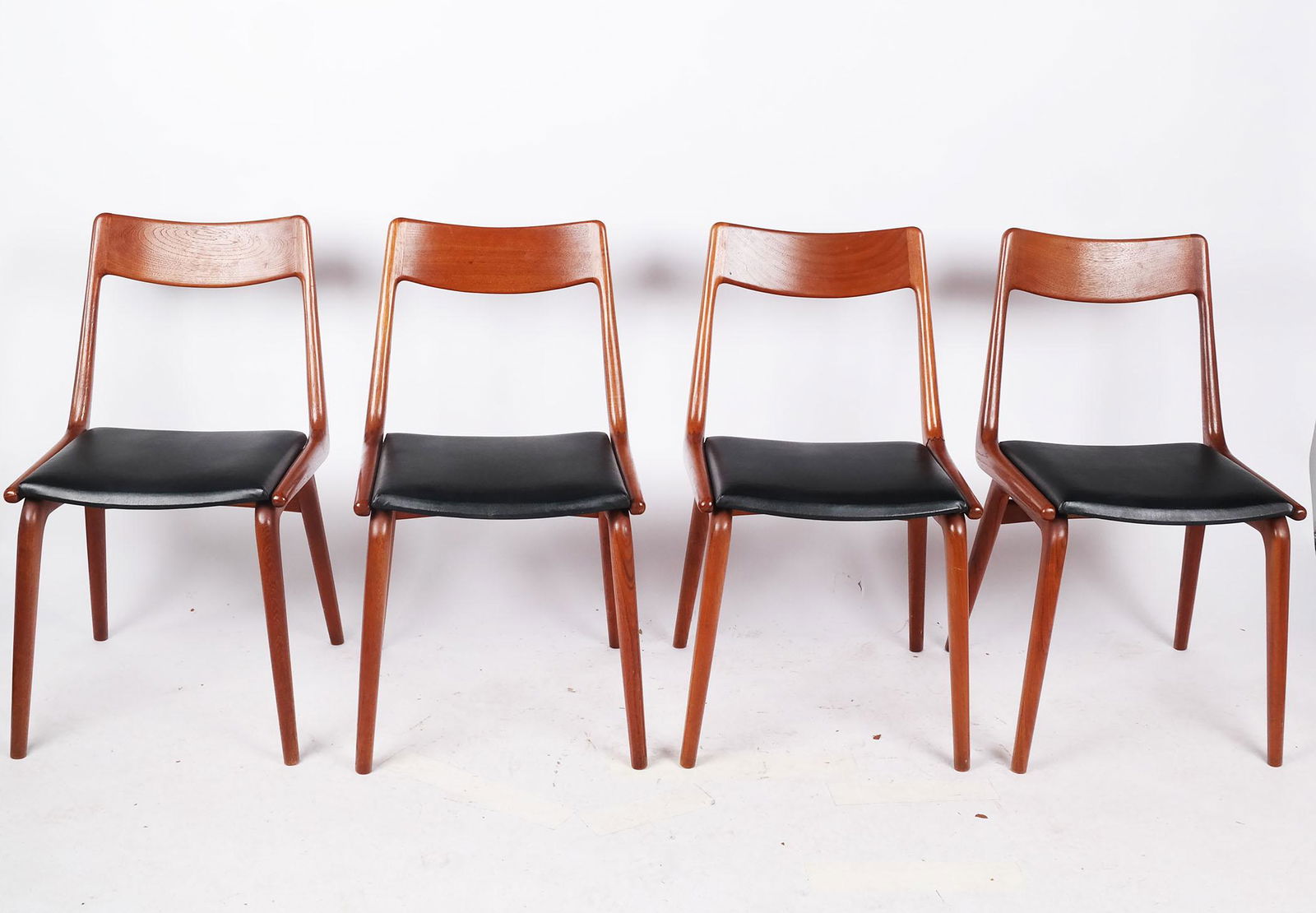 Four Erik Christiansen Mid-Century "Boomerang" Chairs: Four Erik Christiansen Danish mid-century "boomerang" chairs, designed for Slagelse Mobelvaerk (Mobelfabrik), model 370, with teak frames and black leather seats. [32" H x 19 1/2" W x 19 1/2" D]. Some