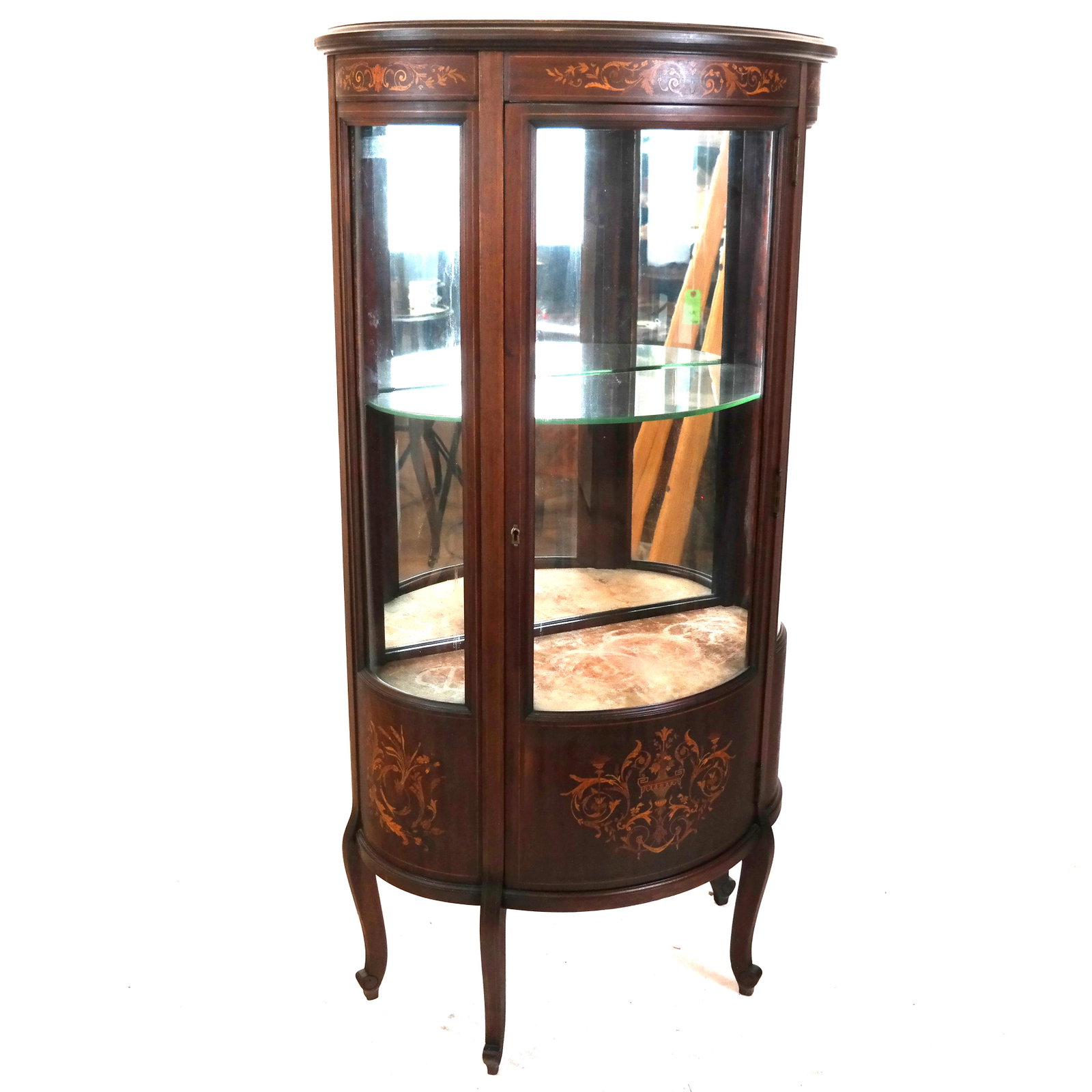 Mahogany Marquetry Inlaid Vitrine Cabinet: Mahogany marquetry inlaid vitrine cabinet, the bowed front with scrolling foliate inlay around glass paned doors. [54 1/2" H x 27 3/4" W x 13 1/2" D]. Tops with crackling and losses, case with cracks,