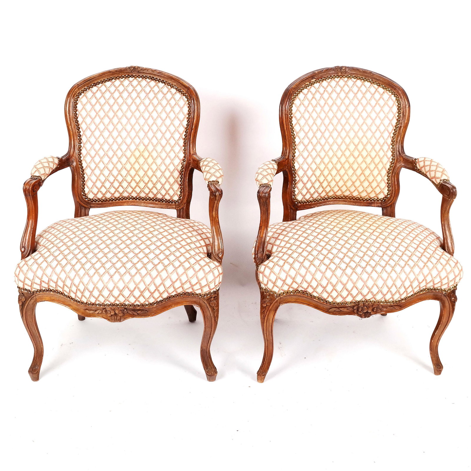 Pair of Louis XV-Style Carved Fauteuils: Pair of Louis XV-style carved and upholstered armchairs, with nail head trim. [34" H x 24" W x 25" D]. Some stains and wear to fabric; typical scuffs and dings to frames.