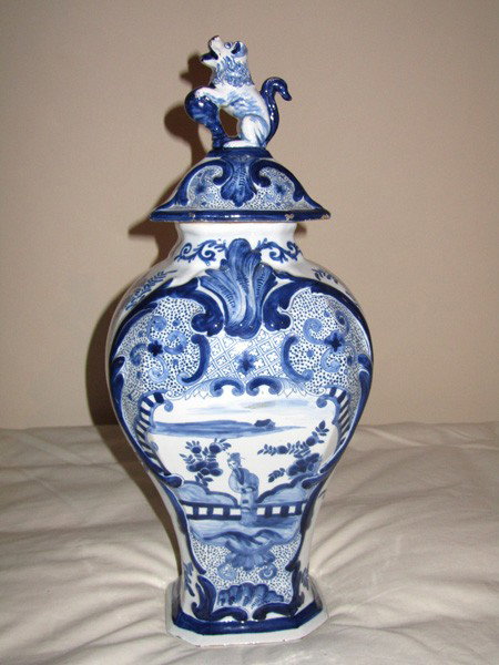 Chinese Covered Urn: Blue and white porcelain decorated covered urn. Having a dog form applique. Minor losses, overall good condition. 18" H.