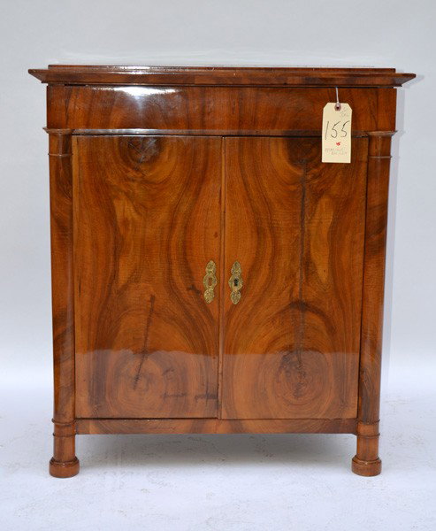 Biedermeier Cabinet: Oyster shell Biedermeier cabinet having one drawer above two doors with column supports. 30.5" L x 17.75" D x 34.75" H.