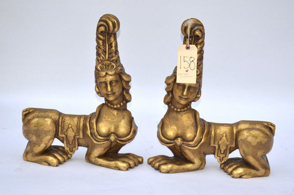 Pair of Carved Gilt Wood Sphinx Decorative Objects: Pair of carved gilt wood whimsical sphinx-form decorative objects. 15.25" W x 3.5" D x 19.75" H.