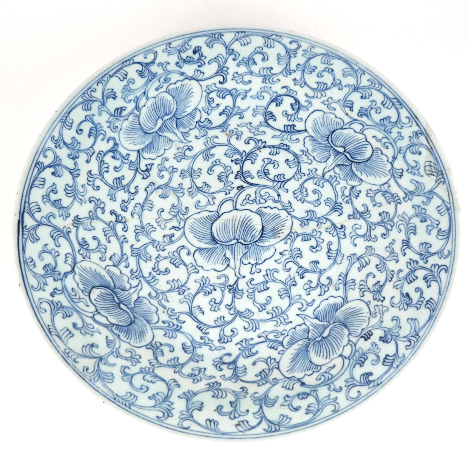 Chinese Blue & White Porcelain Charger: Chinese blue and white porcelain charger, overall with lotus flower and scrolling details. [2 1/4" H x 14 3/4" Diam.]. Full width repaired crack and restorations.