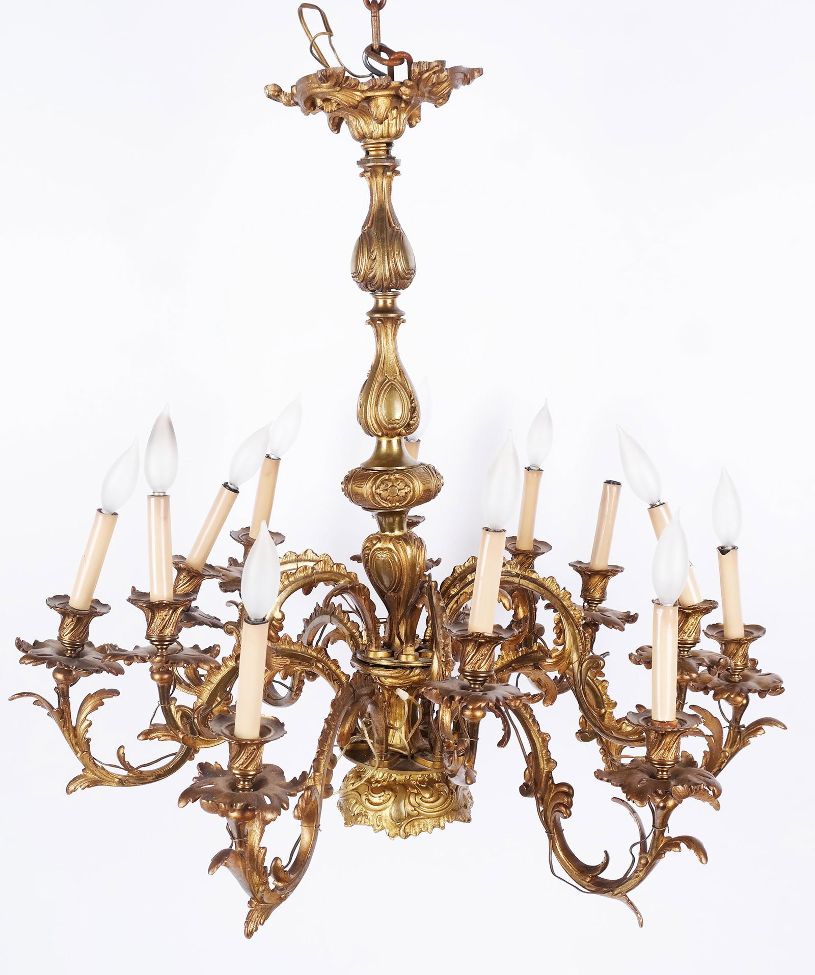 Louis XV-Style Gilt Bronze Chandelier: Louis XV-style gilt bronze chandelier with 12-lights and rocaille scrolling details. [31" H x 33" Diam.]. Arms loose, some bending and oxidation.