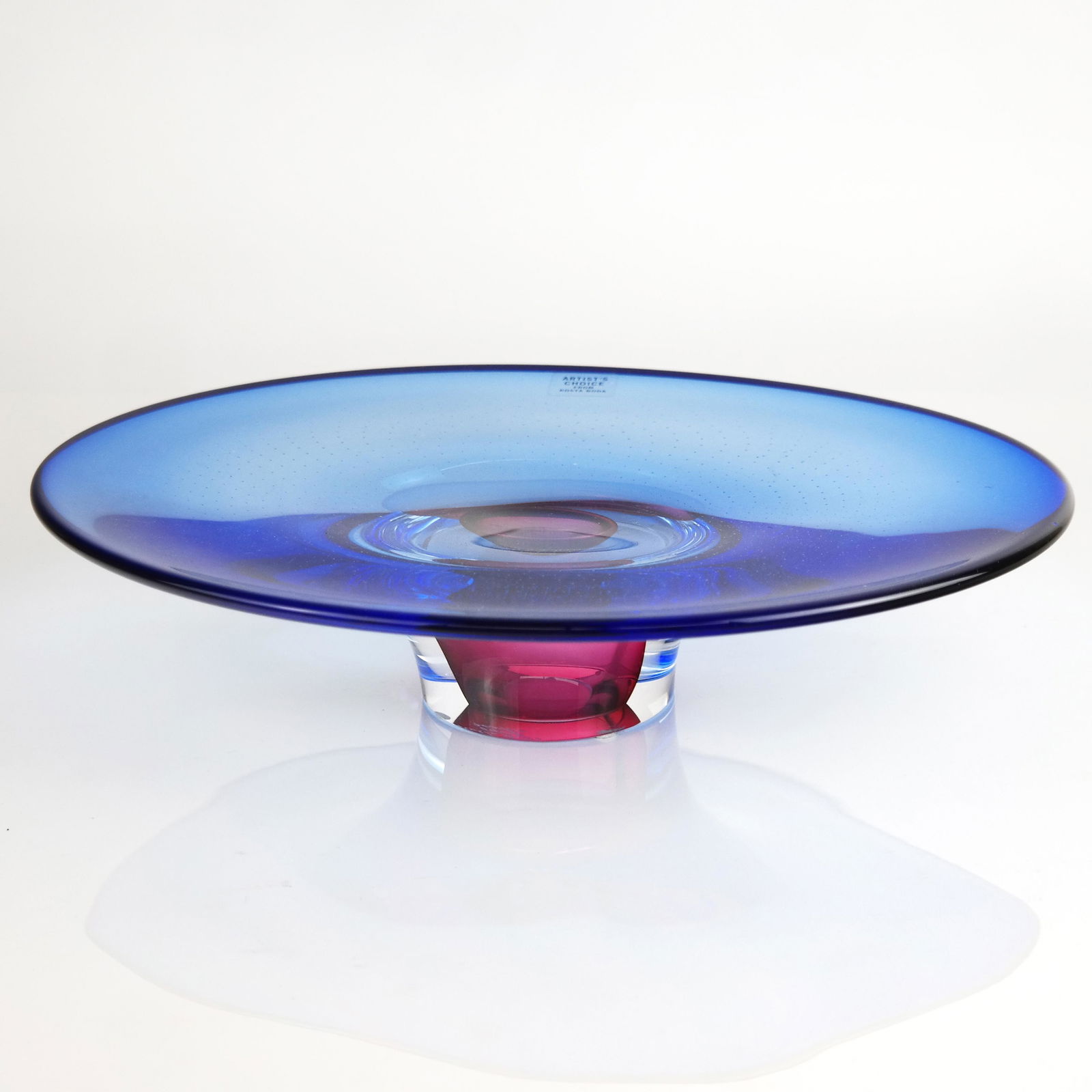 Kosta Boda Blue Glass Centerpiece: Kosta Boda blue glass oblong centerpiece on purple base, by Goran Warff. [3" H x 9 1/2" W x 12 1/2" D].
