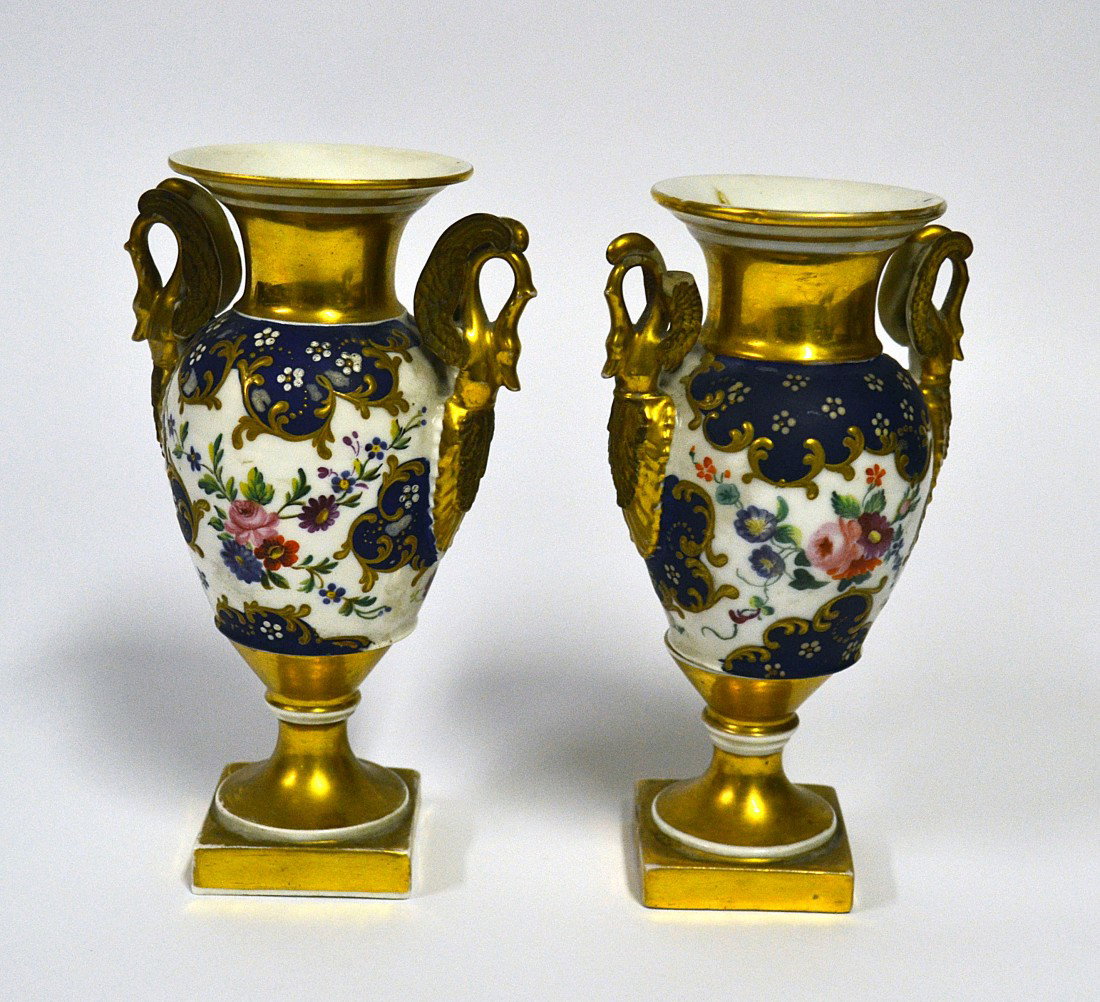 Pair of Paris Porcelain Cabinet Vases: Pair of Antique Empire style gilt and enameled Paris porcelain cabinet vases. Each feature floral décor and swan-form handles. Minor loss to one handle, otherwise in good condition. 7.75" H x 4" W.