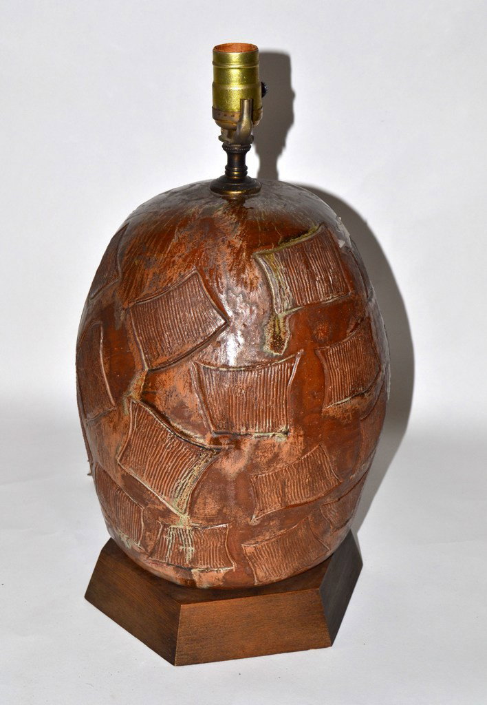 Mid-Century Modern Sculptural Ceramic Table Lamp: Mid-century modern sculptural ceramic ovoid table lamp. Featuring a mottled brown glaze with incised surface texture. Mounted on a 6 sided finished wood base. 9.25" D at base and 17.25" H to socket.