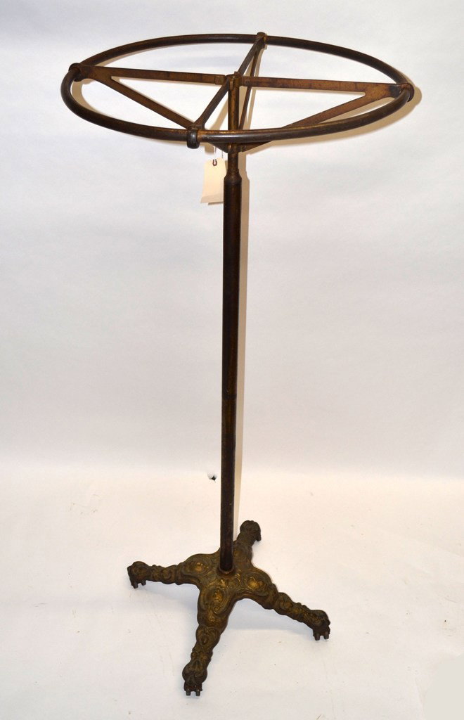 Victorian Industrial Designed Garment Rack: Victorian industrial designed circular steel garment rack on elaborate cast iron Rococo revival style base with metal castor feet. 30.5" Dia at base x 74.5" H.