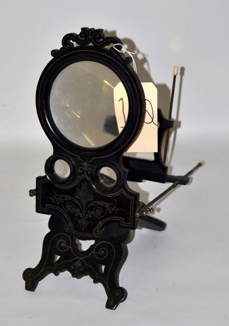 Antique Ebonized Victorian Graphoscope: Antique Victorian collapsible fold-down graphoscope. Composed of a large magnifier above a pair of stereo optic eye pieces contained within an ebonized wood frame with incised and pierced décor. 7.5"