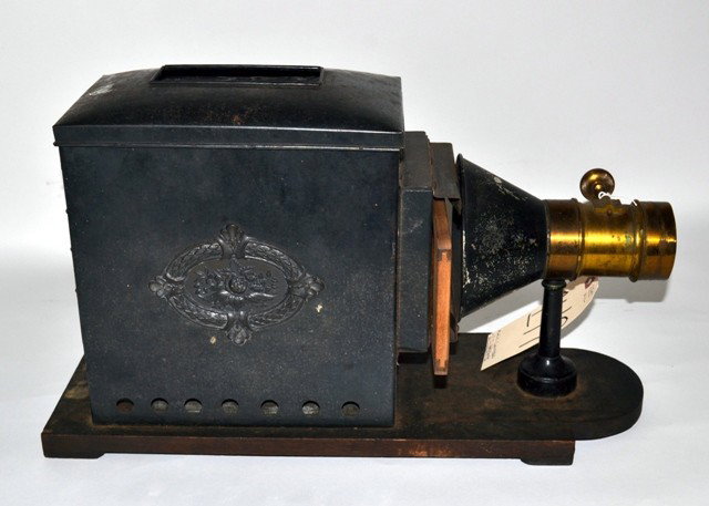 Antique Magic Lantern, "T. J. Harbach Philadelphia: Magic lantern by T. J. Harbach of Philadelphia, PA. Bears a brass lens fitting, tole enclosure, and wooden base with sliding extension. Needs light source. 6.75" W x 18.25" D (30" D extended), minor p
