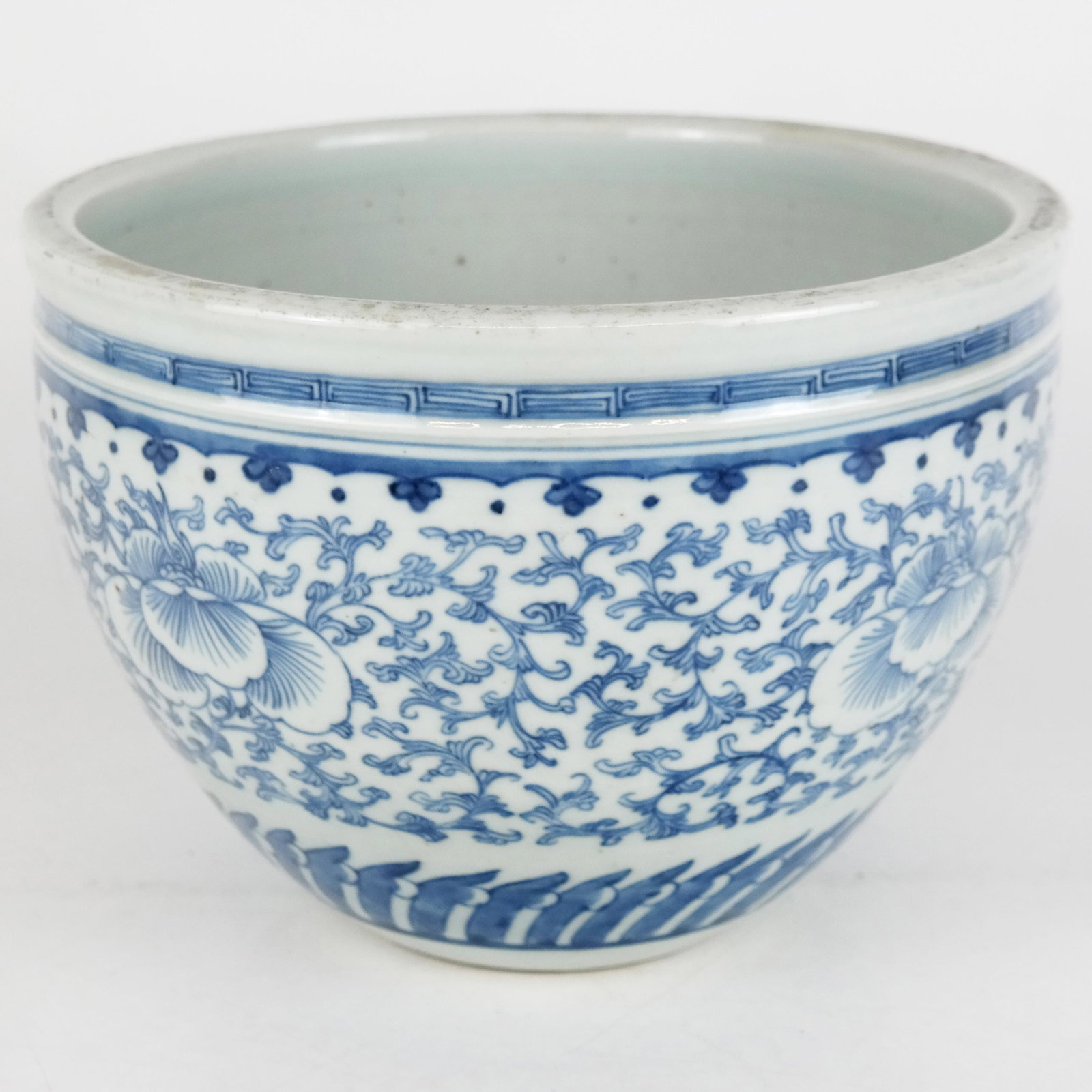 Chinese Blue & White Porcelain Fish Bowl: Chinese blue and white porcelain fish bowl with repeating lotus flower and scrolling decoration; unmarked. [7 1/2" H x 10 1/2" Diam.]. Minor wear and abrasions.