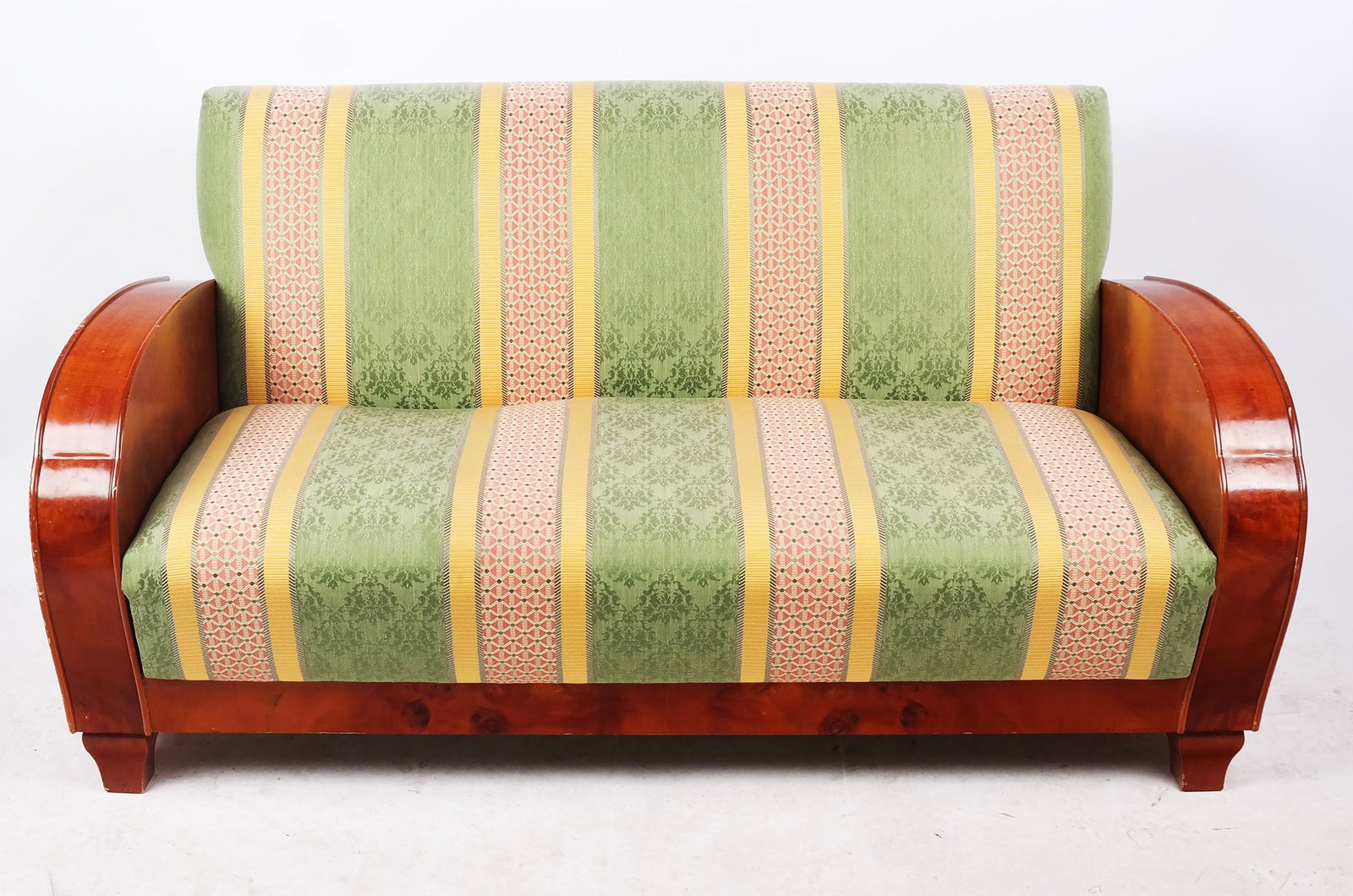 Art Deco Mahogany Sofa Circa 1930: Art deco mahogany sofa in the manner of Harry Epstein, with rounded cloud-form side panels; circa 1930. [32" H x 59 3/4" W x 30" D]. Upholstery later, scattered wear and losses.