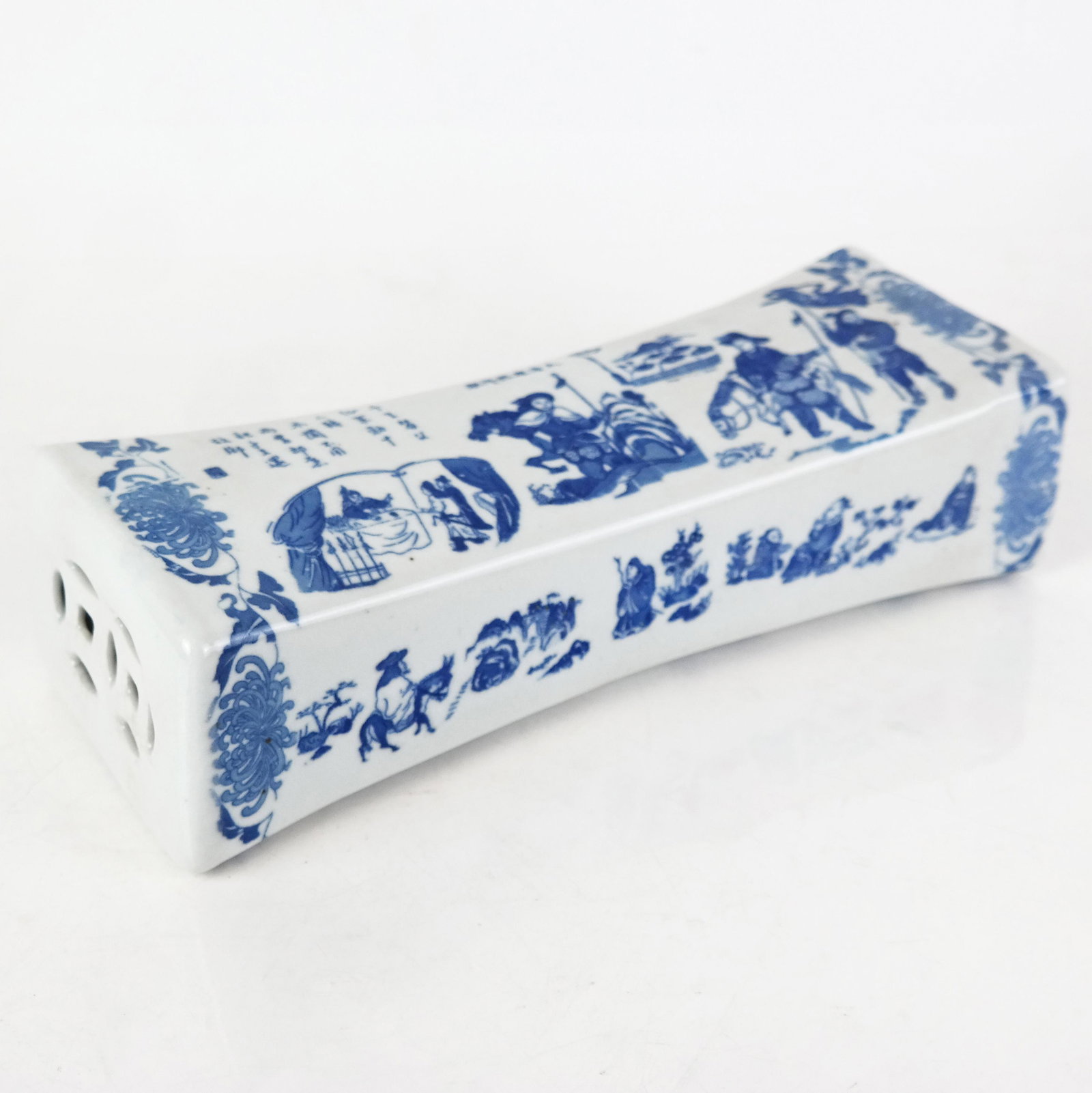 20th Century Asian Porcelain Pillow / Neck Rest: 20th century Asian porcelain pillow/neck rest, decorated in blue with figurative, floral, and calligraphy motifs. [11" H x 4 1/4" W x 3" D]. Mild craquelure and stains to body.